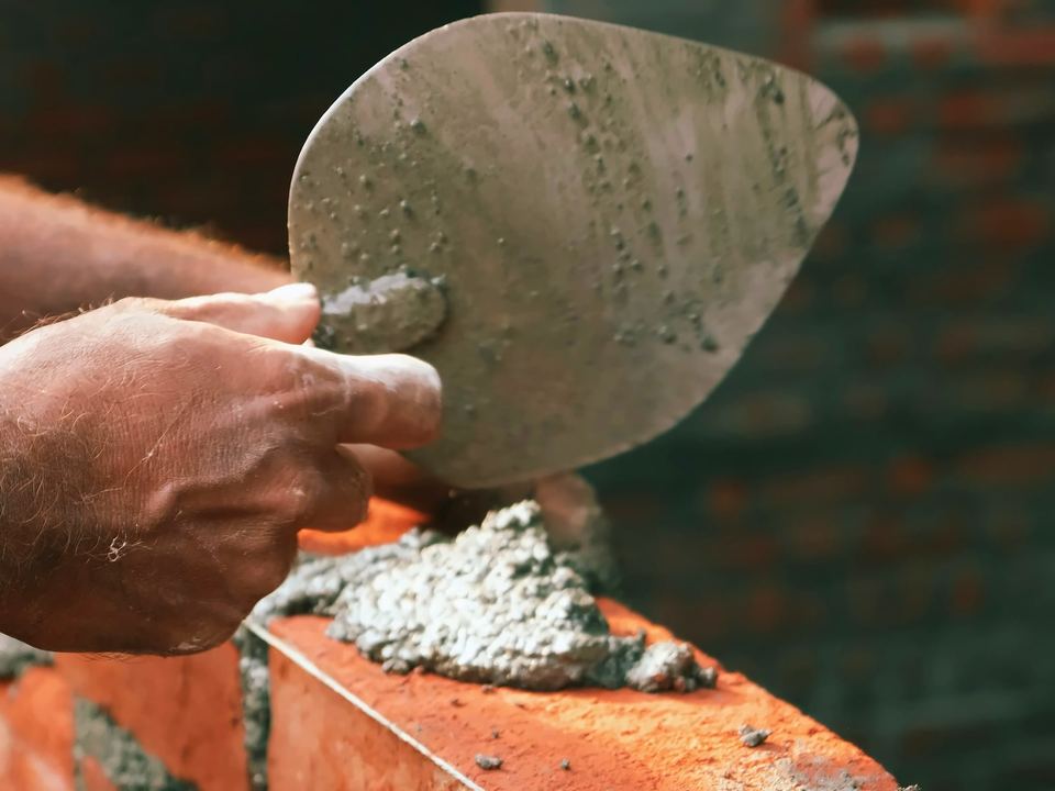 Trowel and mortar on a fresh course of brickwork