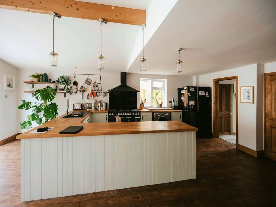 Kitchen with a timber-topped island under a beamed ceiling