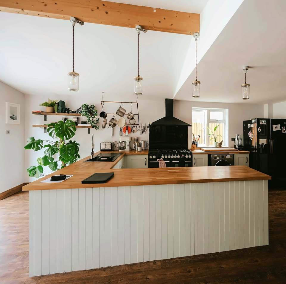 Kitchen with a timber-topped island under a beamed ceiling
